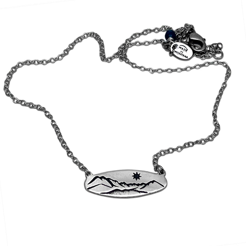 Glacier View Necklace pendant on an adjustable chain, available in matte silver, showcasing mountain and sun design.