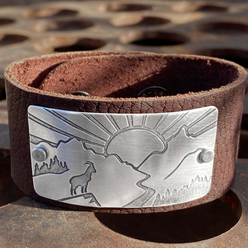 Going to the Sun Road Leather Cuff featuring mountain goat design and sunrise etched in silver.