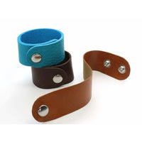 Going to the Sun Road Leather Cuff in assorted colors including blue, brown, and tan, featuring metal snaps.