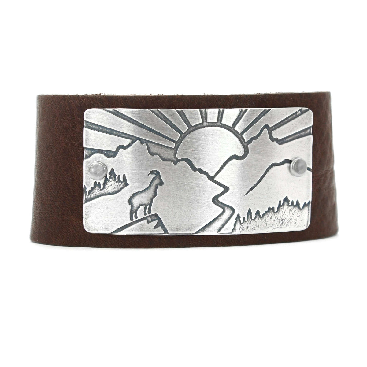 Going to the Sun Road Leather Cuff featuring mountain goat etching and sun design, crafted from leather and metal.
