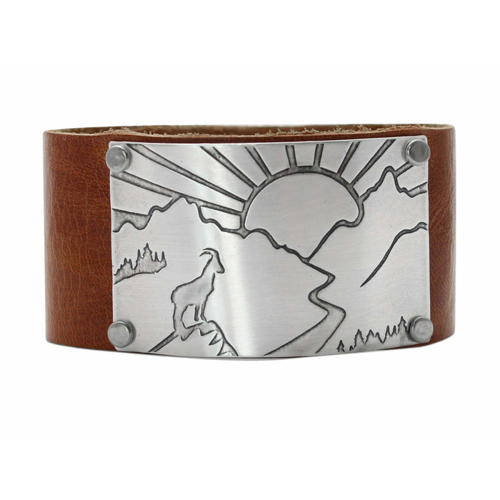 Going to the Sun Road Leather Cuff featuring a mountain goat and sun design on adjustable leather.