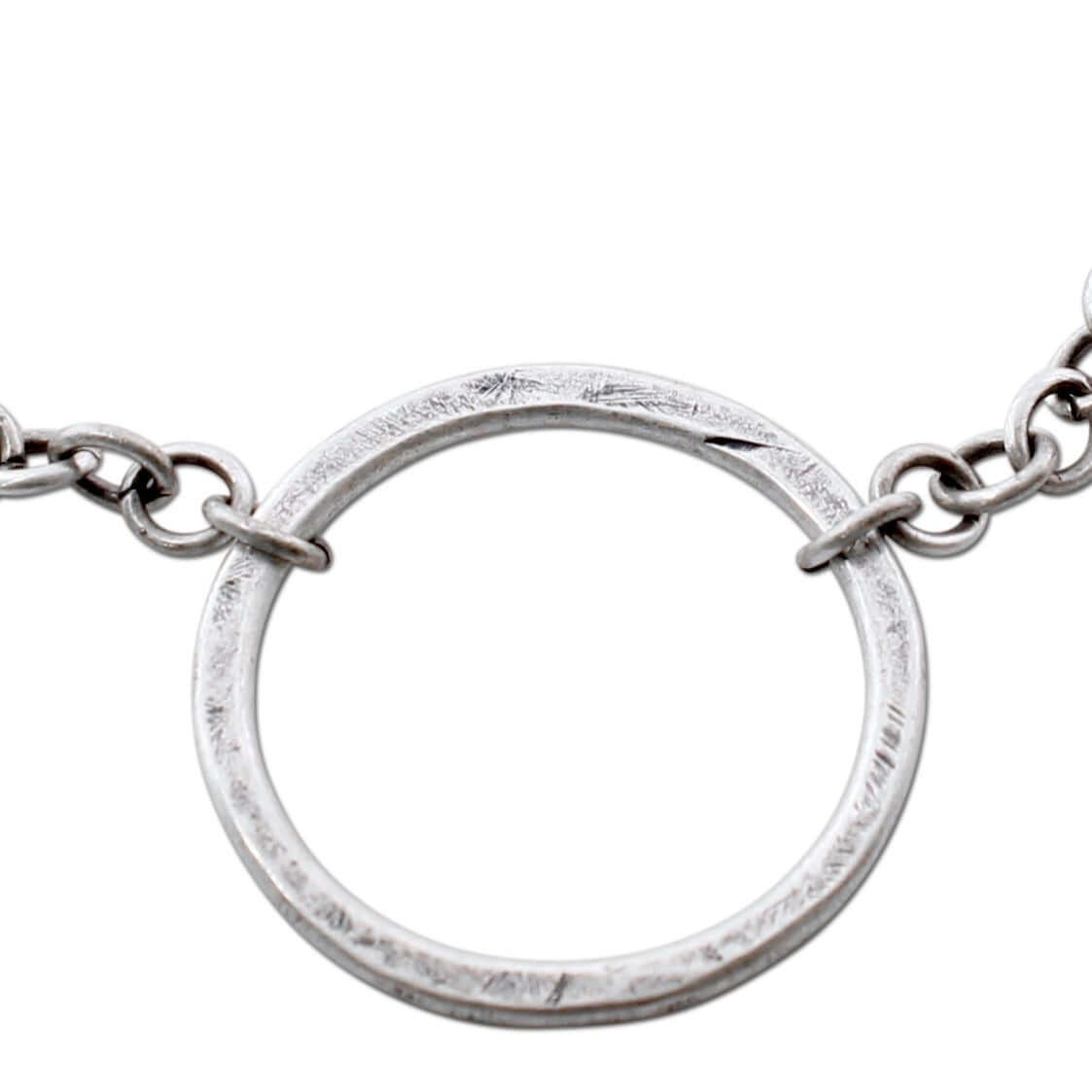 Close-up of a hammered Halo Necklace showcasing the circular pendant on an adjustable chain.