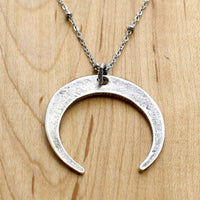 Horned Moon Necklace on satellite chain with matte silver pendant and delicate chain.