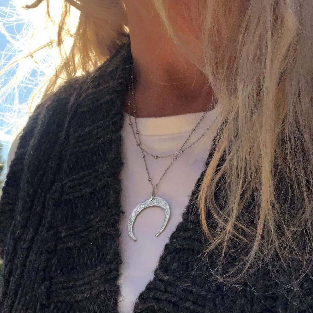 Horned Moon Necklace on satellite chain displayed elegantly on a model, layered with a casual outfit.