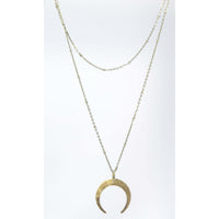 Horned Moon Necklace on satellite chain with gold pendant and layered chains.
