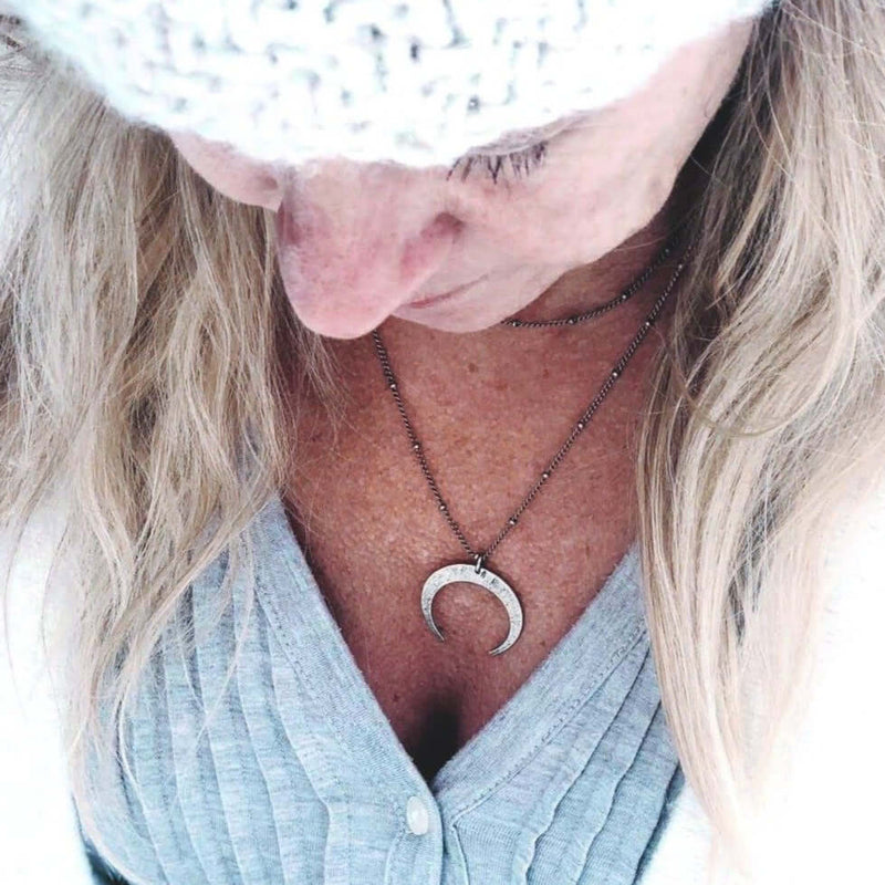 Woman wearing a Horned Moon Necklace on satellite chain, showcasing the elegant pendant and layered chains.