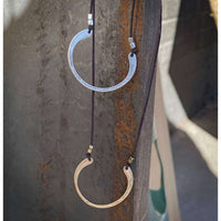 Horseshoe Necklace with semi-circle pendants in silver and gold, hung on black cords