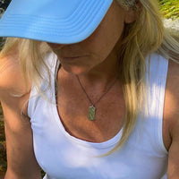 Woman wearing the Howl Necklace featuring a wolf design, showcasing love for wildlife.