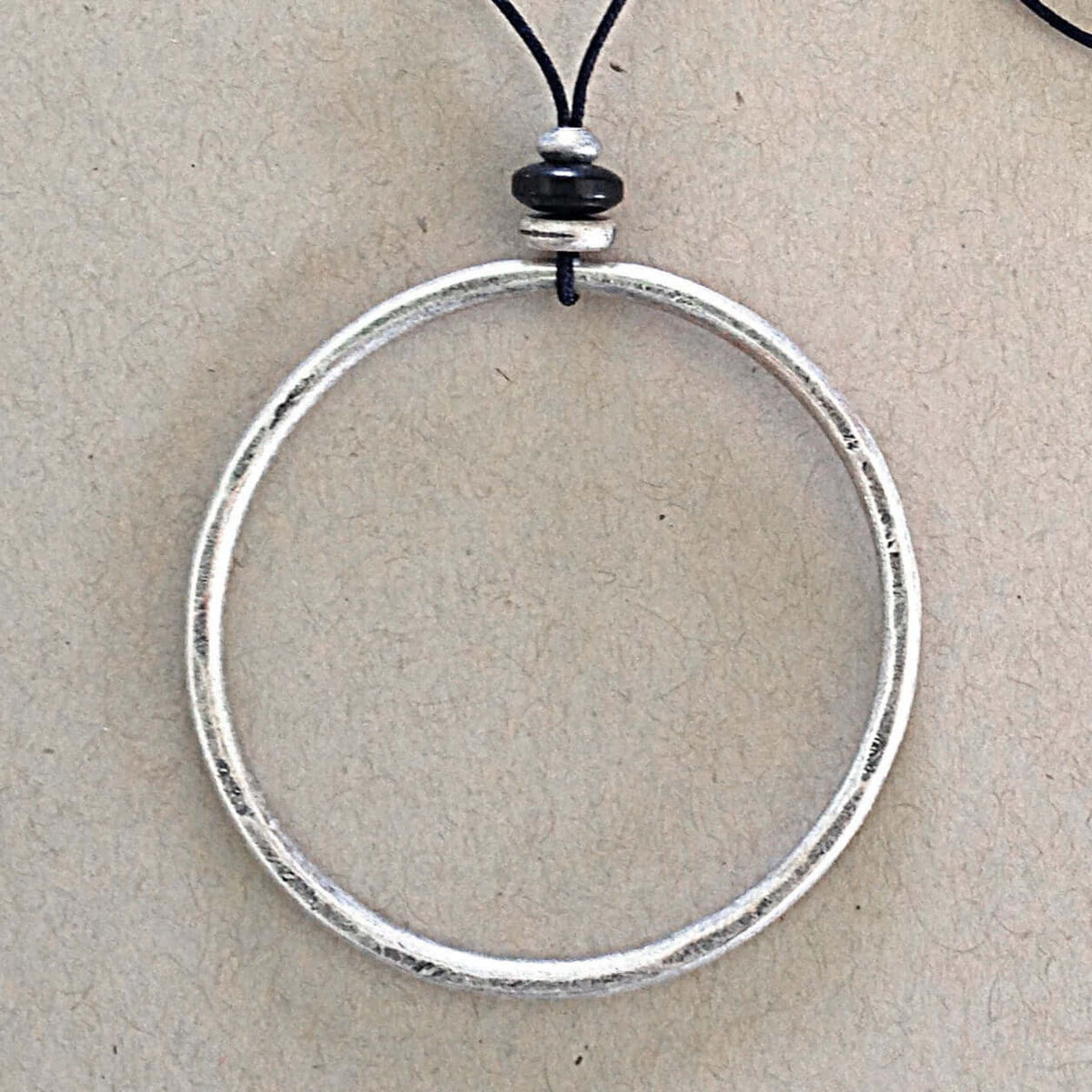 Hula Necklace with a silver-coated circle hoop and bead details on a monofilament cord.