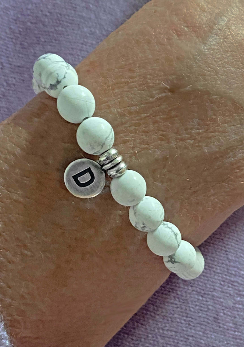 Initial Stretch Bracelet Collection featuring White Howlite beads and a personalized initial disk with letter D.