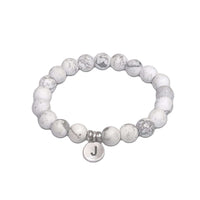 Initial Stretch Bracelet Collection with white howlite beads and a personalized initial disk.