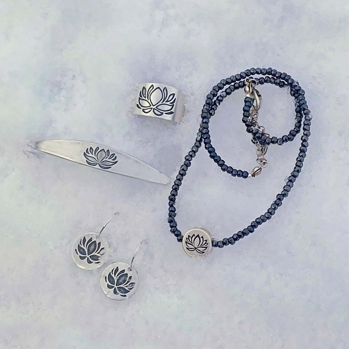 Lotus Adjustable Ring and matching jewelry set featuring etched lotus designs on silver