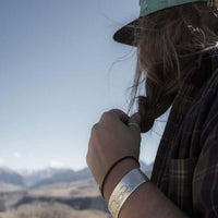 Person wearing a Mama and Cubs Cuff Bracelet outdoors, showcasing a love for nature and family.
