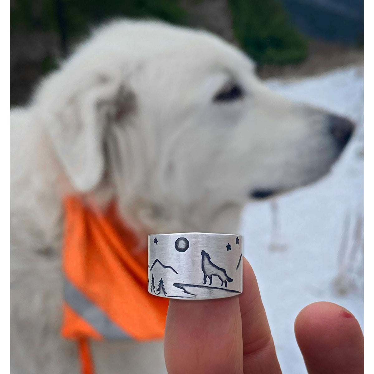 Midnight Wolf Adjustable Ring with wolf design, mountains, and stars, showcased against a snowy background.