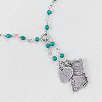 Montana Lariat Necklace featuring turquoise beads, heart charm, and Montana state outline in matte silver finish.