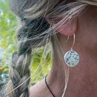 Moon Drops Earrings showcasing hammered raw brass disk, perfect for everyday wear with natural background.