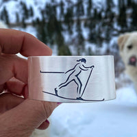 Nordic Run Cuff Bracelet showcasing a skier etched design, perfect for outdoor adventurers and cross country skiing enthusiasts.