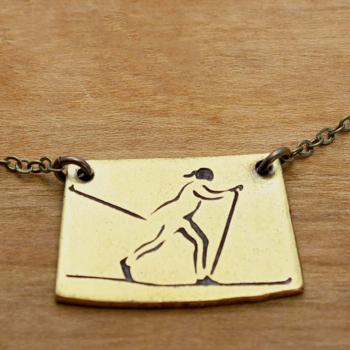 Nordic Run Necklace featuring an etched skier design, perfect for winter sports enthusiasts.