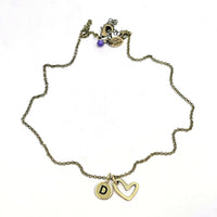 Open Heart Initial Necklace featuring a gold chain with an initial charm and open heart pendant.