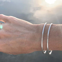 Open Space Cuff Bracelet worn on a wrist, showcasing its sleek Matte Silver finish and sophisticated design.