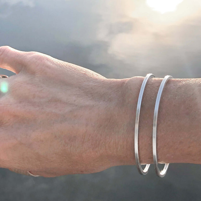 Open Space Cuff Bracelet worn on a wrist, showcasing its sleek Matte Silver finish and sophisticated design.