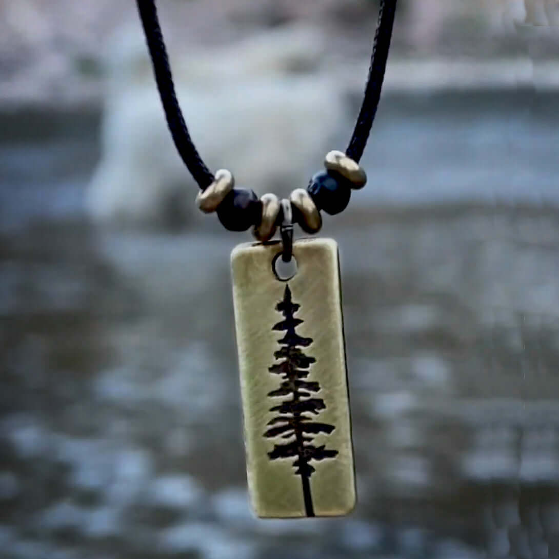 Pine Tree Necklace featuring a Ponderosa Pine pendant on a black cord with beads, ideal for nature enthusiasts.