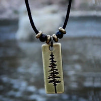 Pine Tree Necklace featuring a Ponderosa Pine pendant on a black cord with beads, ideal for nature enthusiasts.