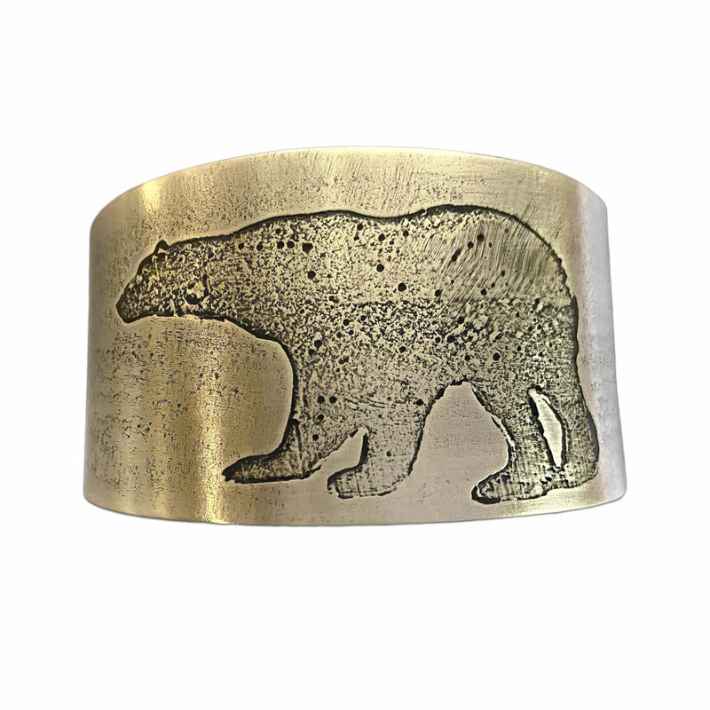 Close-up of a Polar Bear Cuff, showcasing the etched polar bear design on raw brass with a rustic finish.