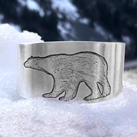 Polar Bear Cuff featuring a raw brass design with a detailed polar bear etching on a snowy background.