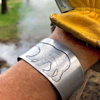 Polar Bear Cuff featuring a detailed polar bear design etched on raw brass, showcasing rustic style and adjustable fit.