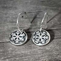 Powder Snowflake Earrings in silver with etched snowflake design on 0.45" disc, hanging from sterling silver earwires.