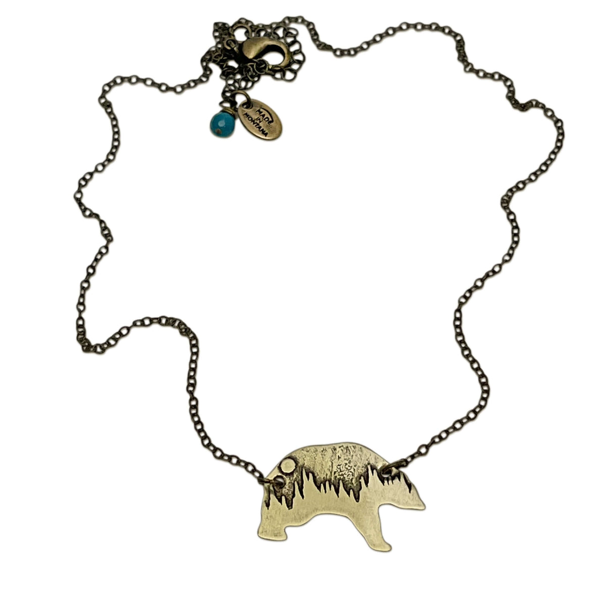 Poya Bear Necklace featuring a bear silhouette and a unique tree line design, made from raw brass on an adjustable chain.