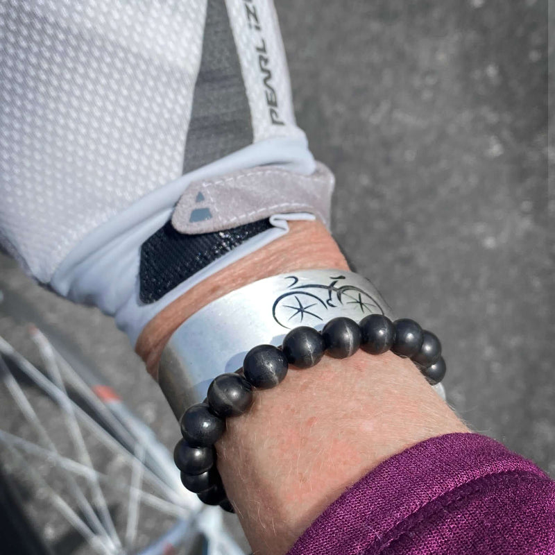 Ride Bicycle Cuff Bracelet worn on wrist with a beaded bracelet, perfect for biking enthusiasts.