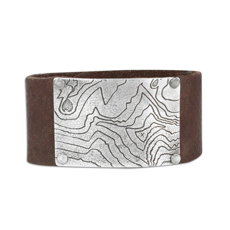 Rising Wolf Leather Cuff Bracelet featuring a topographic map design on a brown leather cuff.
