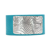 Rising Wolf Leather Cuff Bracelet featuring a topographic map with matte silver finish on turquoise leather.