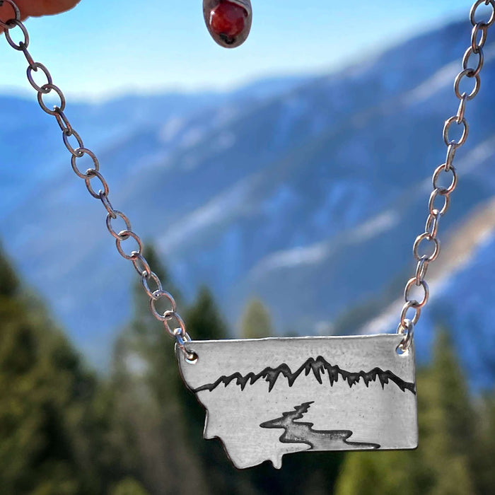 River Run Necklace featuring Montana outline, a mountain peak, and winding river, perfect for outdoor adventures.