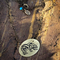 Rocky Bear Necklace featuring a grizzly bear pendant on a bronze chain, perfect for lovers of nature and adventure.