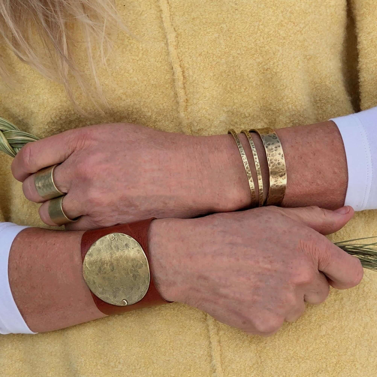 Set of Three Thin Cuff Bracelets worn together with a leather cuff on a woman's wrist.