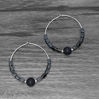 Shun Hematite Beaded Hoop Earrings with shungite and hematite beads on a wooden surface.