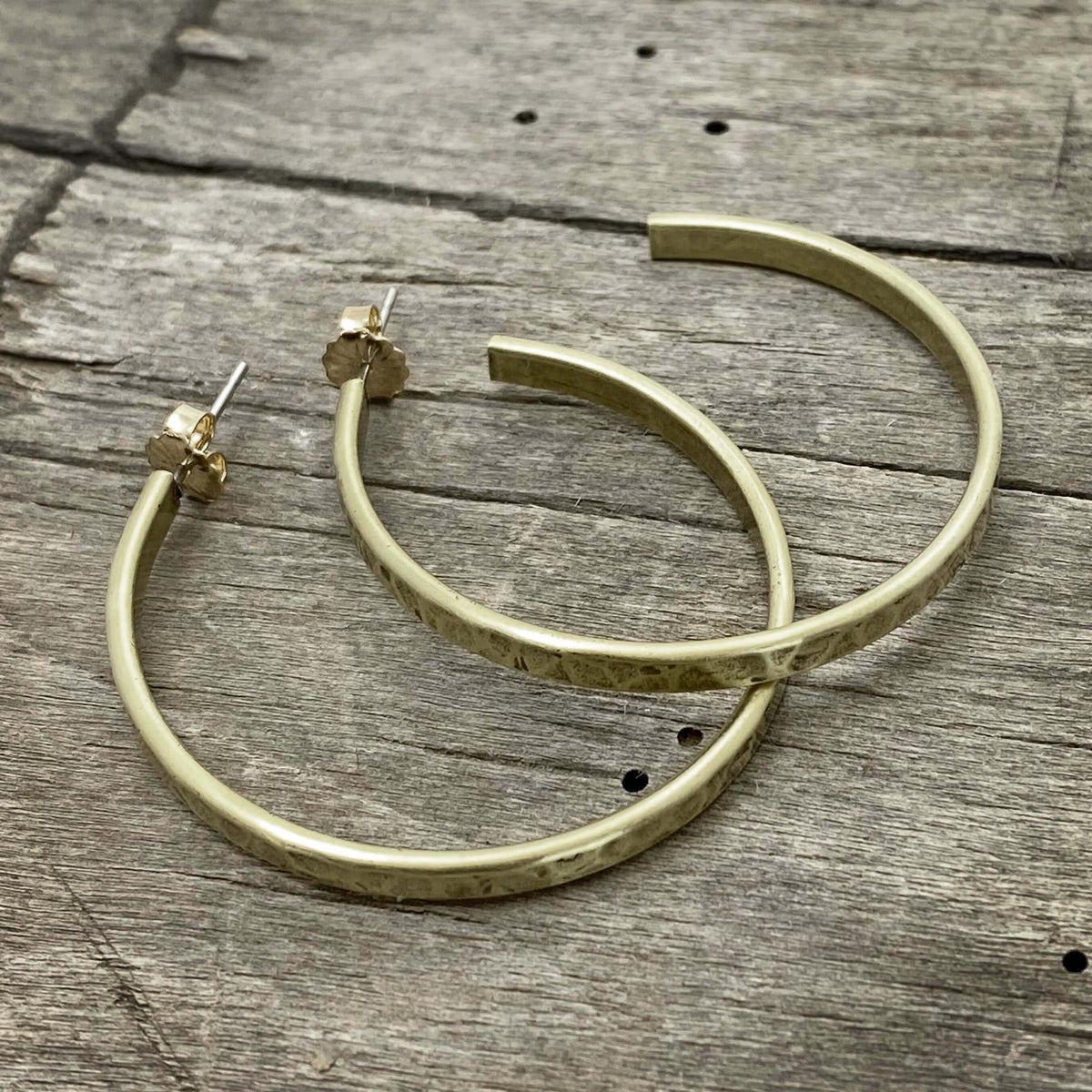 Simple Hoop Earrings in hammered brass with stainless steel posts and 14k gold ear nuts, perfect for everyday wear.