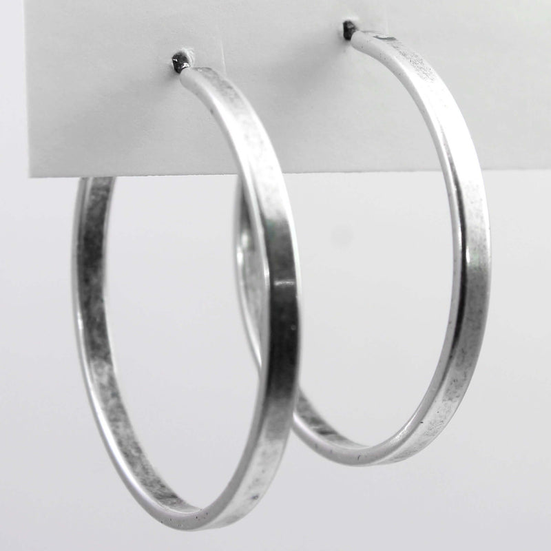 Simple Hoop Earrings displayed on a card, showcasing smooth silver finish and 1.5 inch diameter.