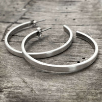 Simple Hoop Earrings - chic hammered silver hoops on wooden background.