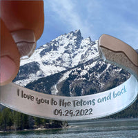 Close-up of the Simple Tetons Cuff Bracelet against a scenic mountain backdrop, perfect for nature lovers.