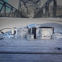 Skinny Bear Cuff Bracelet collection featuring unique designs and textures on metal accessories.