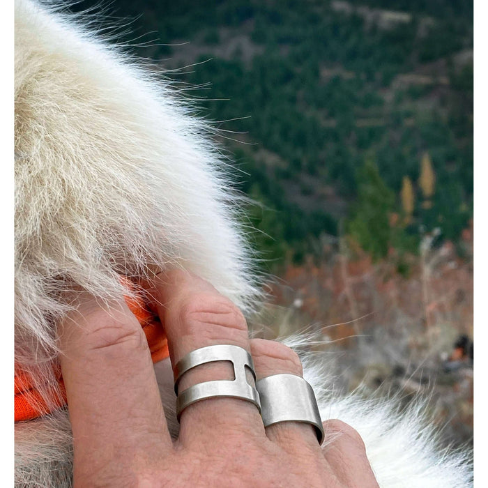 Wearing a Slate Adjustable Ring in Matte Silver against a scenic outdoor backdrop.