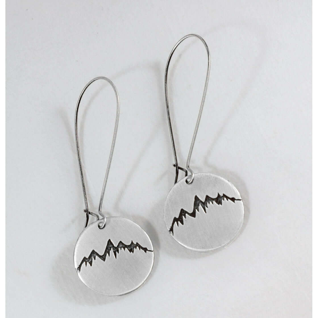Snowcap Mountain Earrings featuring snowcapped mountain peaks in circular disks with long kidney earwires.