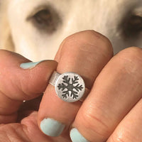 Snowflake Adjustable Ring on a hand, showcasing the etched snowflake design against a blurred background.