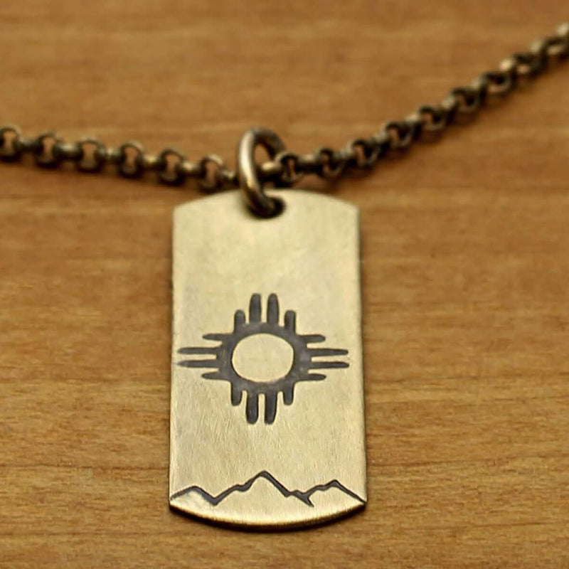 Sol Necklace featuring a Zia sun design on raw brass, highlighting the unique craftsmanship and style.