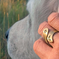 Solar Adjustable Ring worn on a hand, featuring a sun and crescent moon design in antique brass finish.