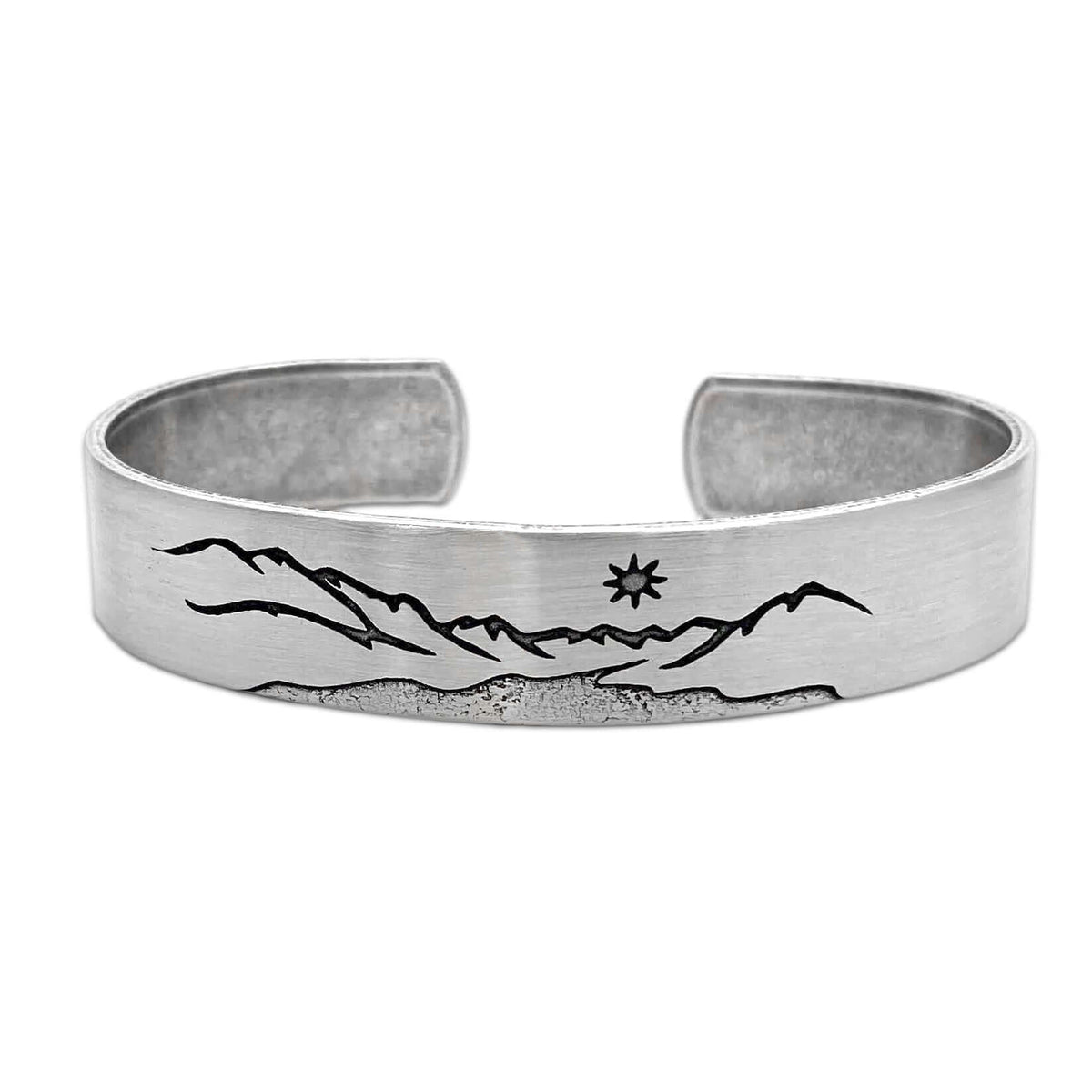 St. Mary Cuff Bracelet featuring a mountain and star design on a silver cuff, 1/2 inch wide and adjustable.
